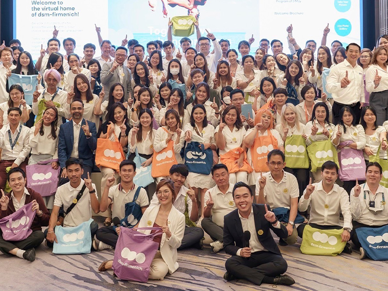 Group picture of many employees showing their new logo swag (photo)