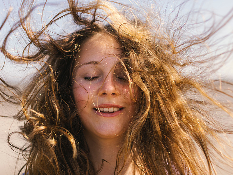 Closeup of a person with long hair blowing in the wind (photo)