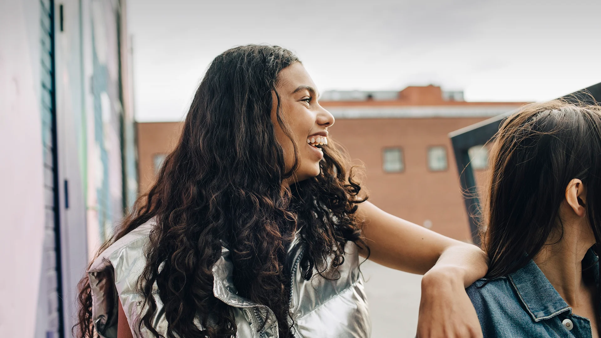 A girl with a silver jacket laughing (photo)