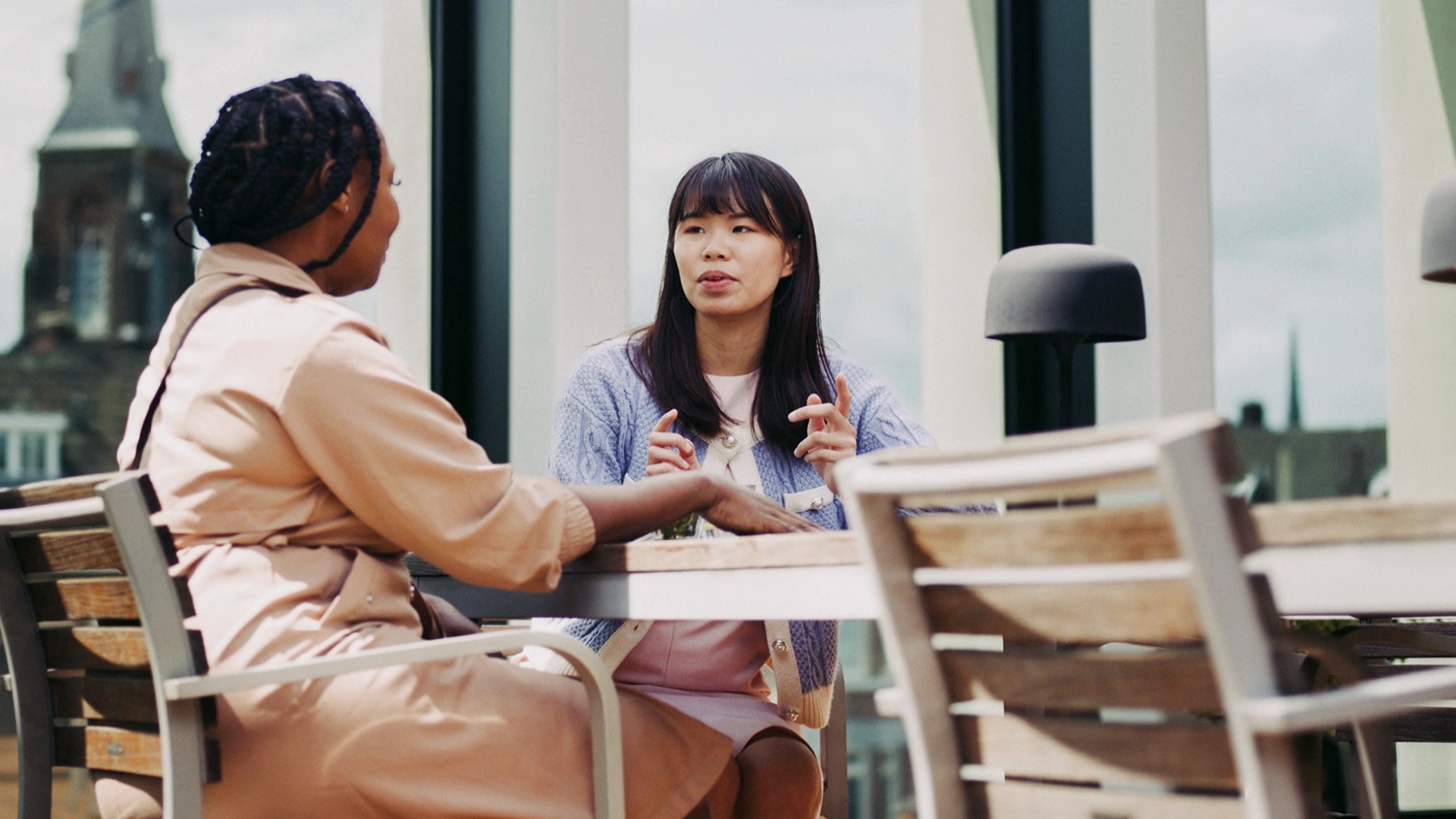 Two women talking on a terrace (photo)