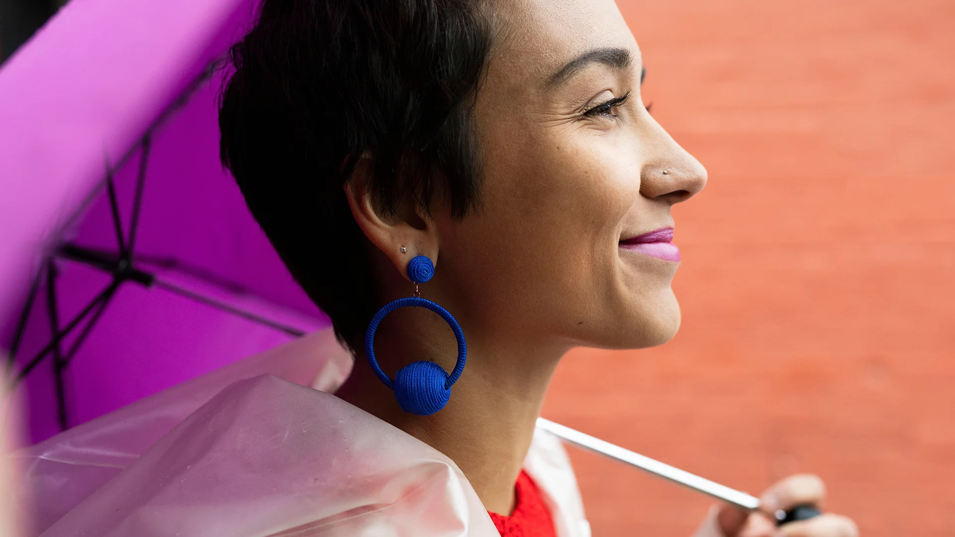 A young woman smiling and holding a purple umbrella (photo)