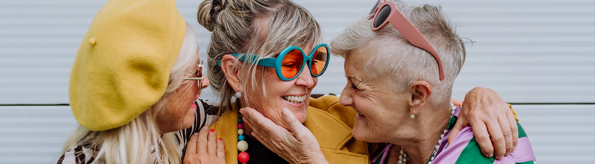 Three woman in colorful clothes hugging (photo)