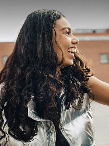 A girl with a silver jacket laughing (photo)