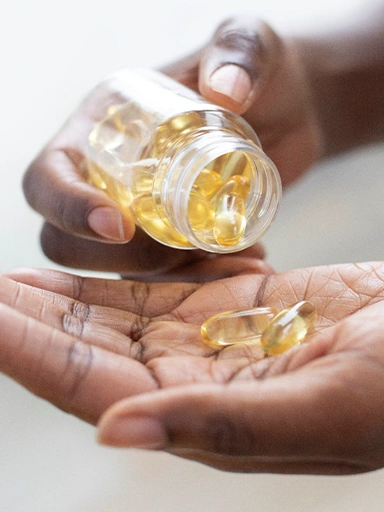 A person holding a glass full of yellow pills (photo)