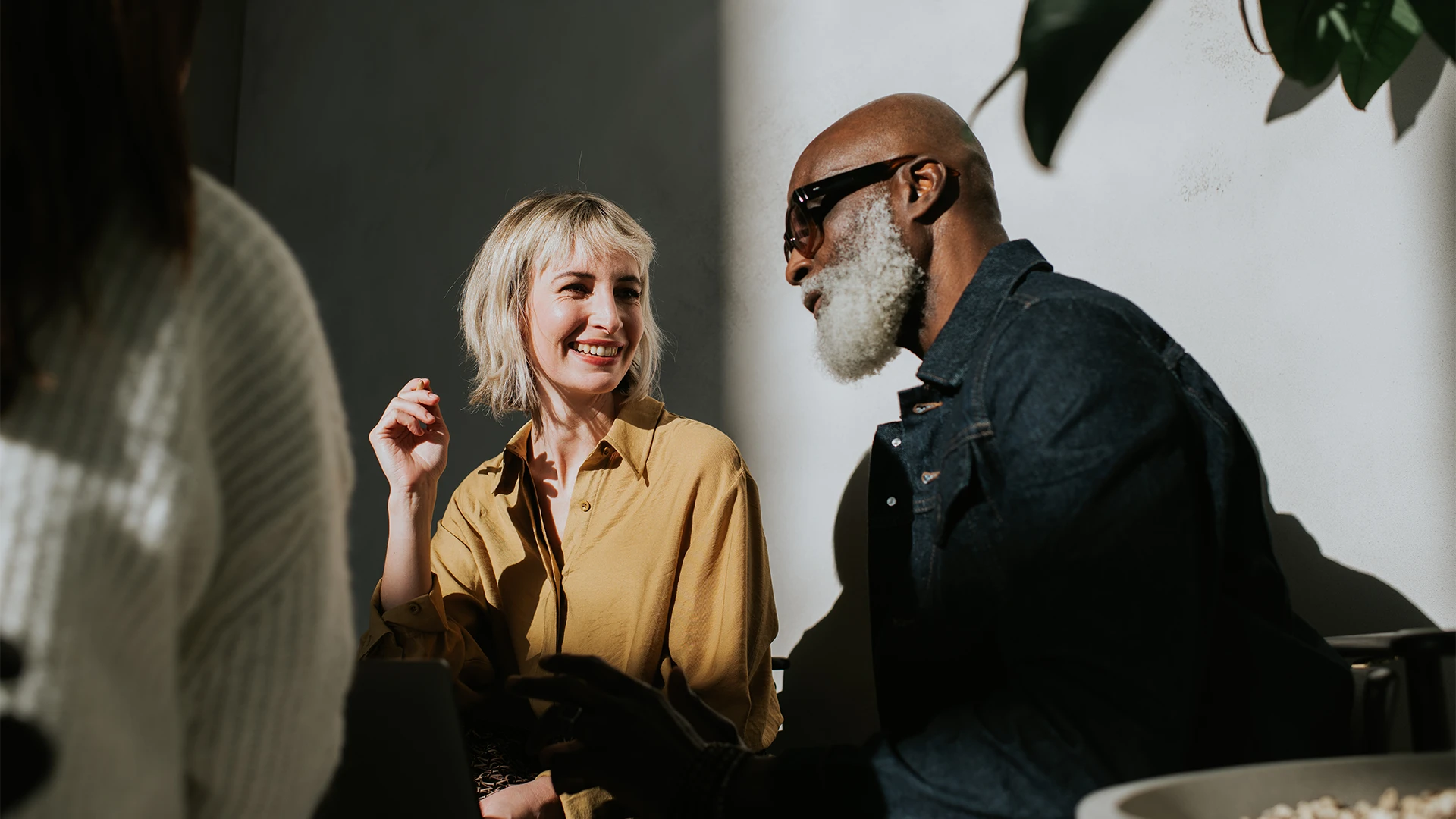 Two people sitting together and talking, smiling in a bright indoor setting. (photo)