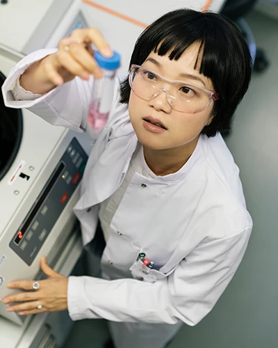 Scientist holding a sample tube in a laboratory. (photo)